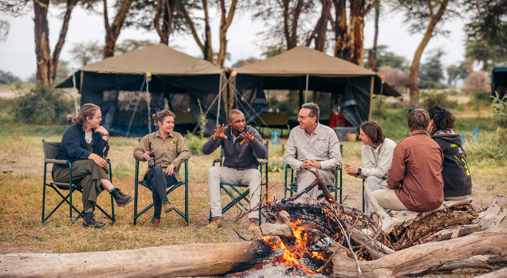 Guests of the Mobile Explorer Camp sitting around the fire listening to the guide telling stories. Guests of the Mobile Explorer Camp sitting around the fire listening to the guide telling stories.