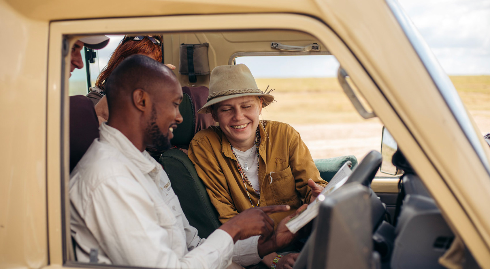 Gast und Guide schauen sich im Fahrzeug ein Nachschlagewerk an. Gast und Guide schauen sich im Fahrzeug ein Nachschlagewerk an.