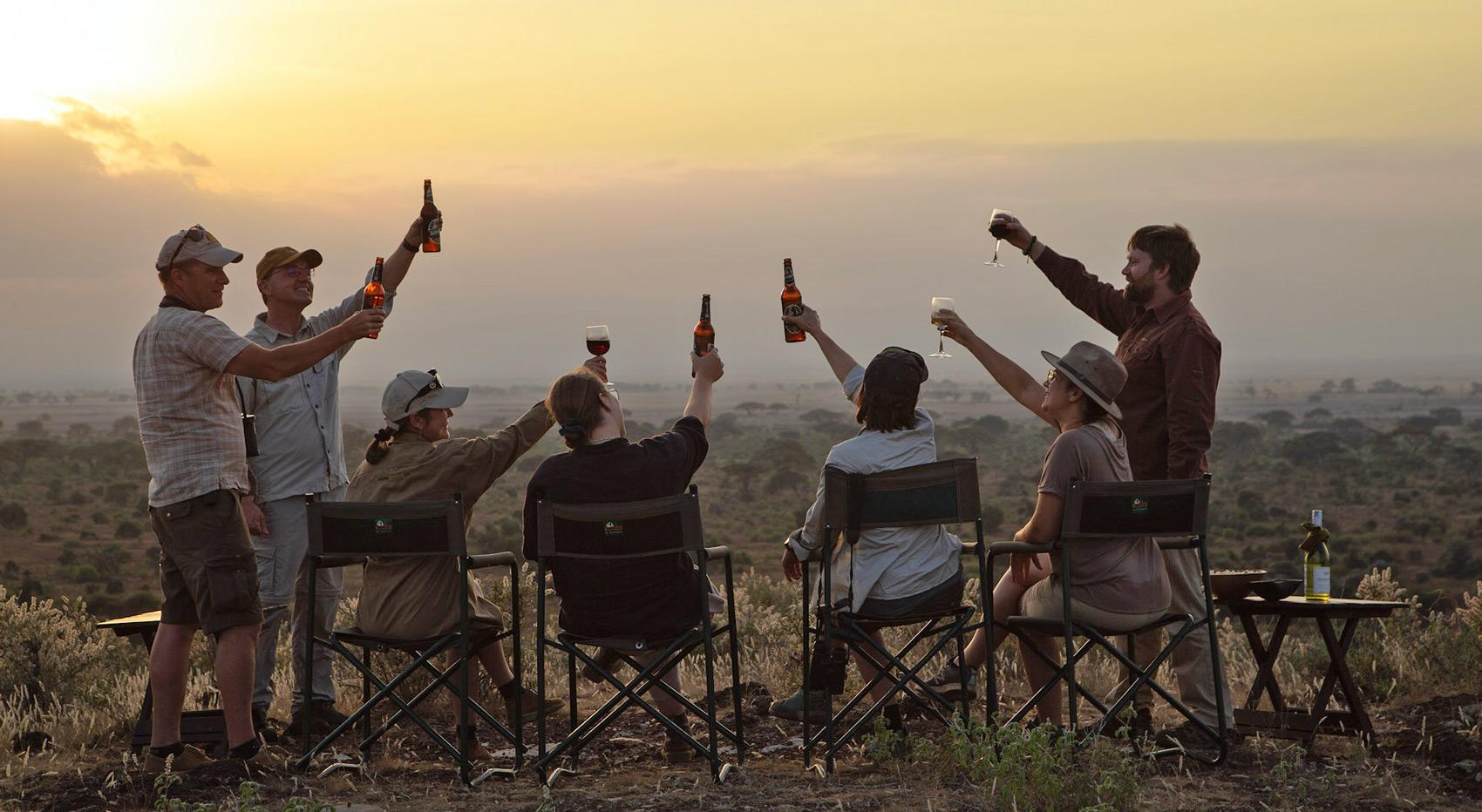 Eine Gruppe von Gästen genießt Sundowner mit weitläufigen Ausblicken.