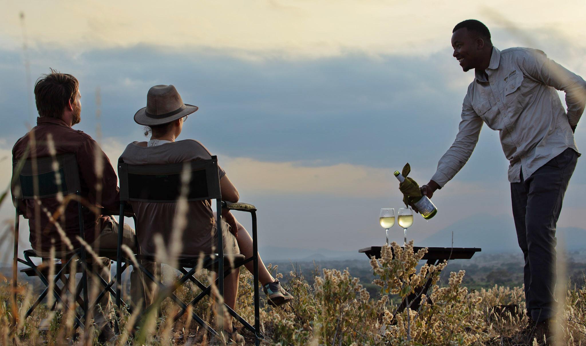Couple having sundowners in Tanzania on safari.