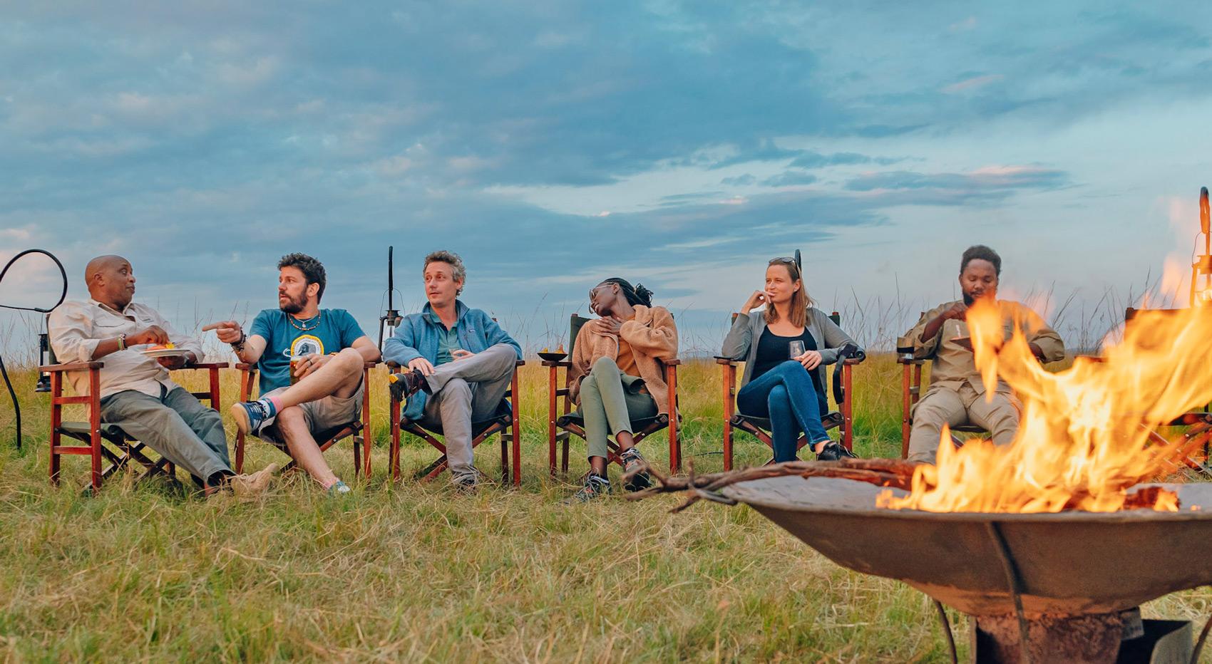 Gäste und ihr Guide am Feuer beim Genießen von Sundownern. Gäste und ihr Guide am Feuer beim Genießen von Sundownern.