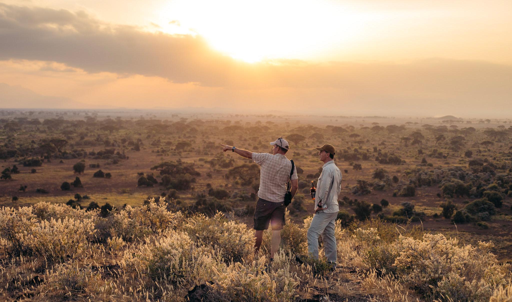 Gäste stehen in West Kilimanjaro und zeigen auf etwas.