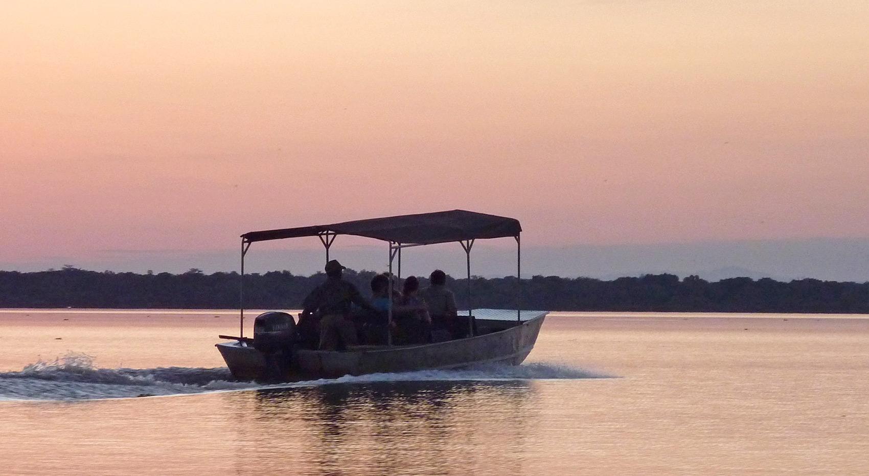 A boat with guests at sunset on the Rufiji River. A boat with guests at sunset on the Rufiji River.