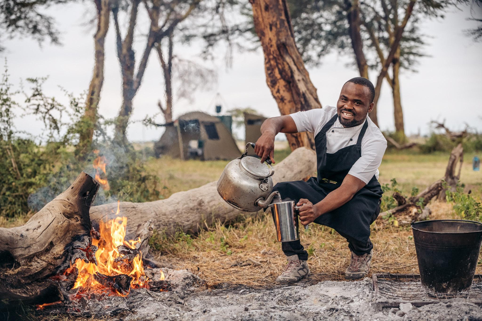 A mobile camp team member making coffee over the open fire. A mobile camp team member making coffee over the open fire.